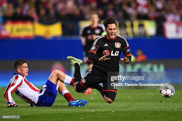 Jose Gimenez of Atletico Madrid fouls Hakan Calhanoglu of Bayer Leverkusen during the UEFA Champions League round of 16 match between Club Atletico...