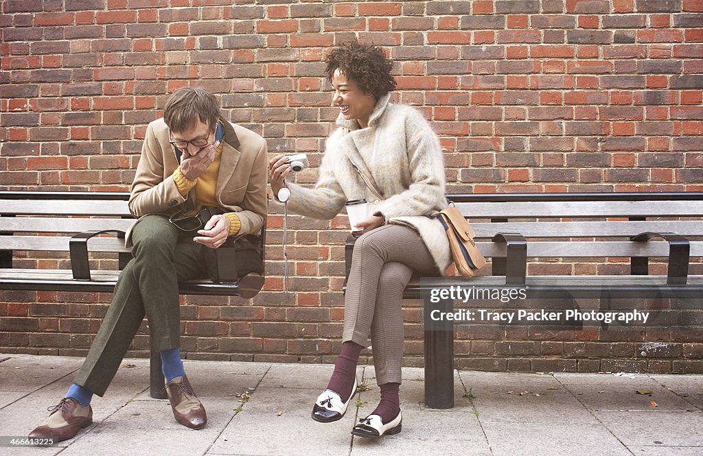 A man and woman view photographs on a camera