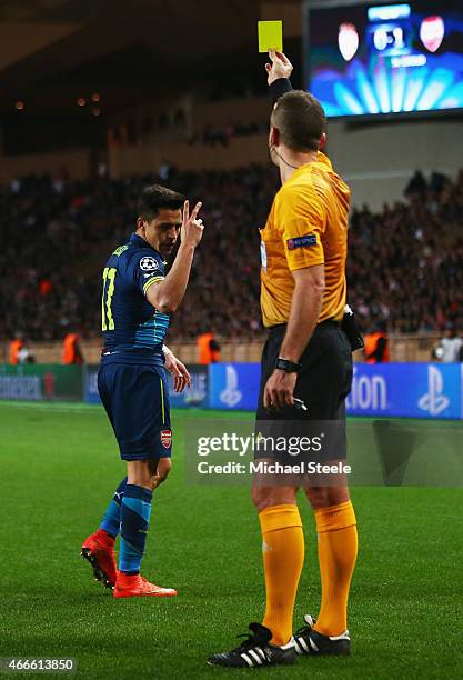 Alexis Sanchez of Arsenal reacts as he is shown a yellow card by referee Svein Oddvar Moen during the UEFA Champions League round of 16 second leg...