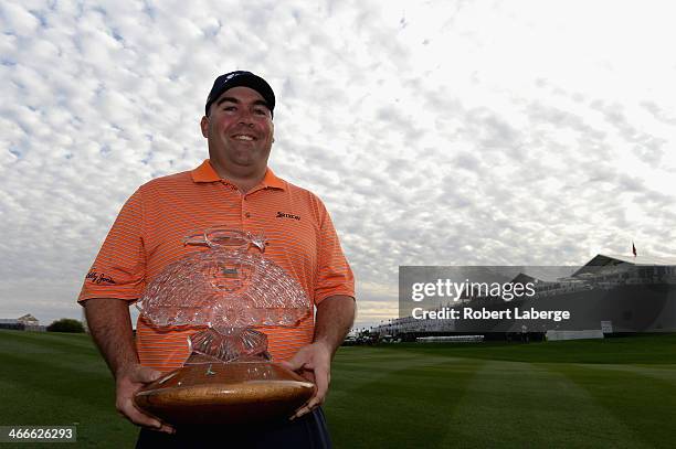 Kevin Stadler poses with the championship trophy after winning the Waste Management Phoenix Open at TPC Scottsdale on February 2, 2014 in Scottsdale,...