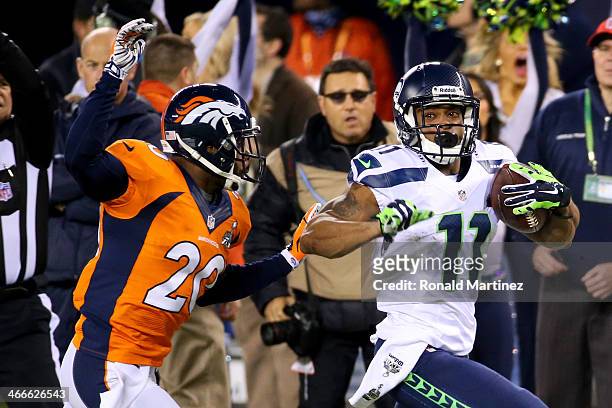 Wide receiver Percy Harvin of the Seattle Seahawks runs the ball 30-yards against free safety Mike Adams of the Denver Broncos in the first quarter...
