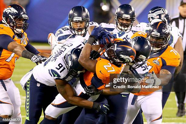 Running back Knowshon Moreno of the Denver Broncos is tackled by Chris Clemons, defensive end Cliff Avril and outside linebacker K.J. Wright of the...