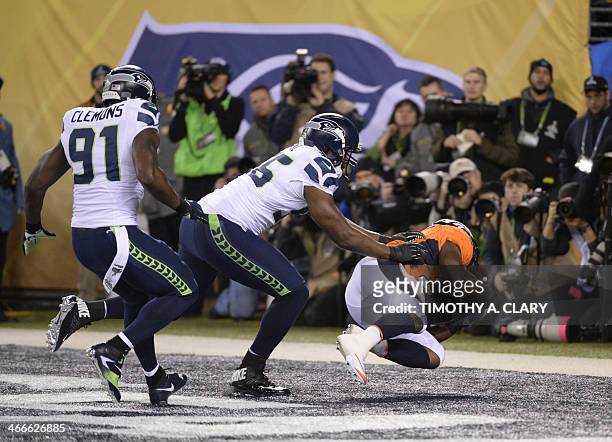 Chris Clemons and Cliff Avril of the Seattle Seahawks put pressure on Knowshon Moreno of the Denver Broncos for a safety on the first play of Super...