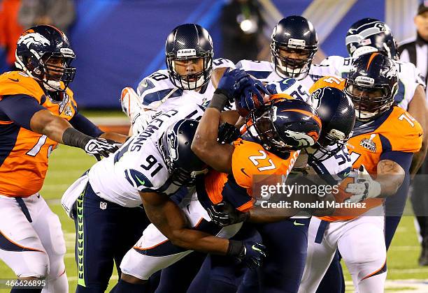 Running back Knowshon Moreno of the Denver Broncos is tackled by Chris Clemons, defensive end Cliff Avril and outside linebacker K.J. Wright of the...