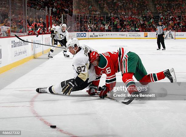 Jacob Josefson of the New Jersey Devils takes down Sidney Crosby of the Pittsburgh Penguins during the first period at the Prudential Center on March...