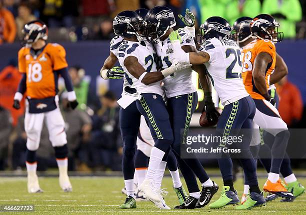 Strong safety Kam Chancellor of the Seattle Seahawks celebrates his interception with teammates against the Denver Broncos in the first quarter...