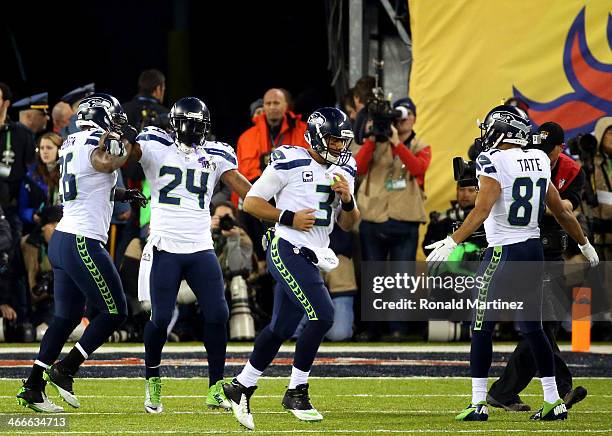 Running back Marshawn Lynch of the Seattle Seahawks celebrates his 1-yard touchdown with teammate fullback Michael Robinson, quarterback Russell...