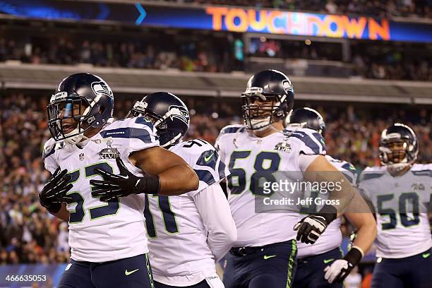 Outside linebacker Malcolm Smith of the Seattle Seahawks celebrates his 69-yard touchdown with teammates after intercepting a pass thrown by...