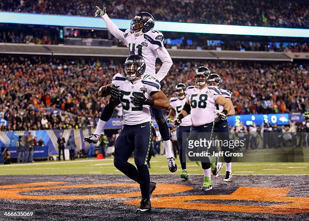 Outside linebacker Malcolm Smith of the Seattle Seahawks celebrates his 69-yard touchdown with teammates after intercepting a pass thrown by...