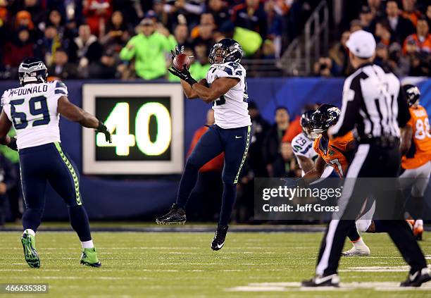Outside linebacker Malcolm Smith of the Seattle Seahawks intercepts a pass intended for running back Knowshon Moreno of the Denver Broncos to run it...
