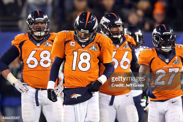 Quarterback Peyton Manning of the Denver Broncos reacts alongside teammates guard Zane Beadles, center Manny Ramirez and running back Knowshon Moreno...