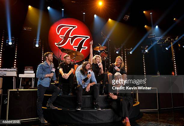 Musicians Chris Shiflett, Nate Mendel, Dave Grohl, comedian/TV personality Chelsea Handler, musicians Pat Smear and Taylor Hawkins speak onstage...