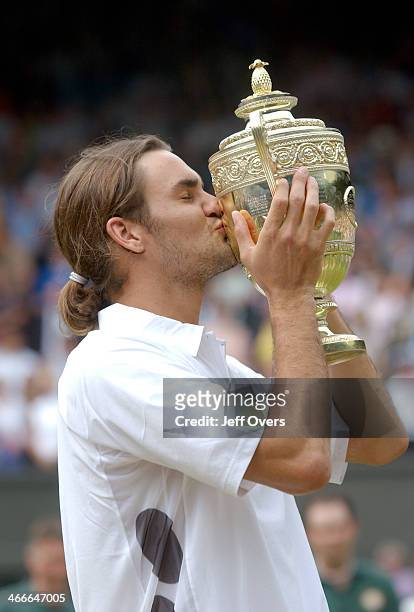 Roger Federer of Switzerland kisses the trophy after his victory over Mark Philippoussis of Australia in the Mens Singles Final during the final day...