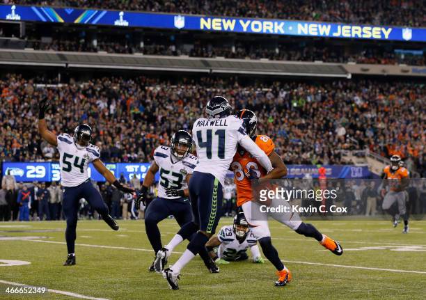 Wide receiver Demaryius Thomas of the Denver Broncos goes up to catch a ball he fumbles against middle linebacker Bobby Wagner of the Seattle...