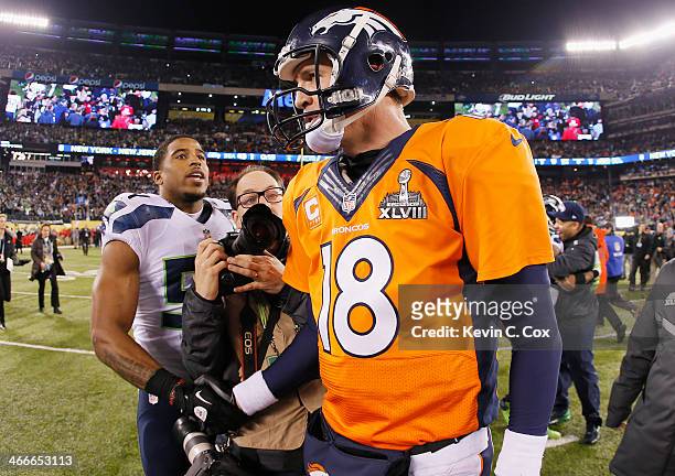 Quarterback Peyton Manning of the Denver Broncos shakes hands with middle linebacker Bobby Wagner of the Seattle Seahawks after their 43-8 loss...