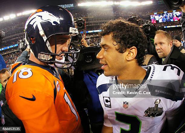 Quarterback Peyton Manning of the Denver Broncos congratulates quarterback Russell Wilson of the Seattle Seahawks on their 43-8 win during Super Bowl...