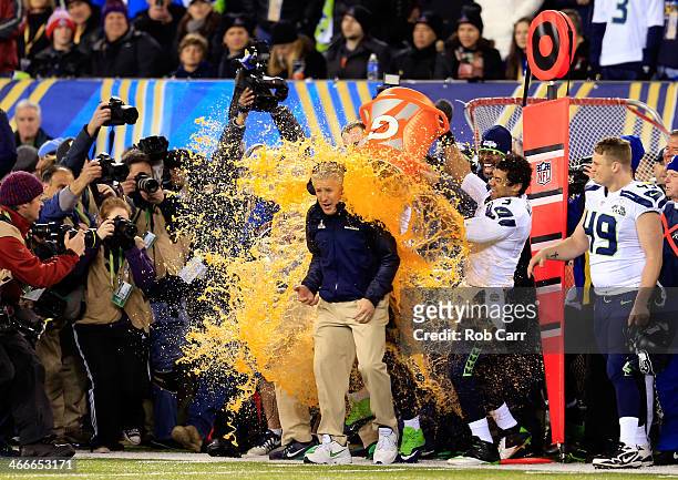 Tight end Zach Miller and quarterback Russell Wilson of the Seattle Seahawks dump Gatorade on head coach Pete Carroll in the fourth quarter of Super...