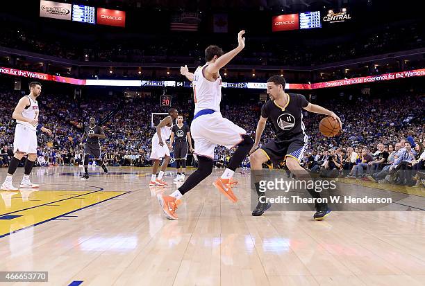 Klay Thompson of the Golden State Warriors dribbles the ball while defended by Alexey Shved of the New York Knicks at ORACLE Arena on March 14, 2015...
