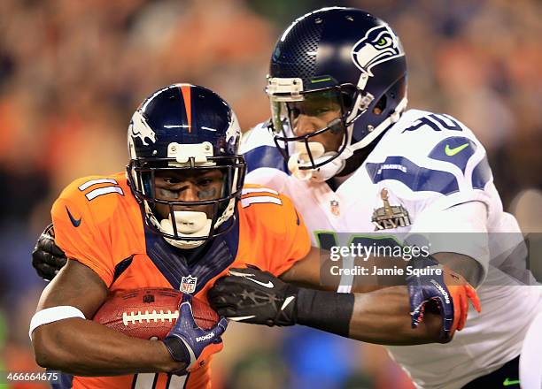 Trindon Holliday of the Denver Broncos runs with the ball against the Seattle Seahawks Derrick Coleman of the Seattle Seahawks defends during Super...