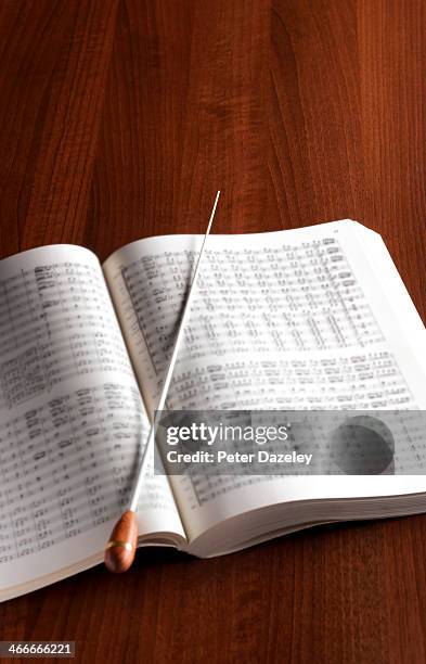 conductor's baton and music - bladmuziek stockfoto's en -beelden
