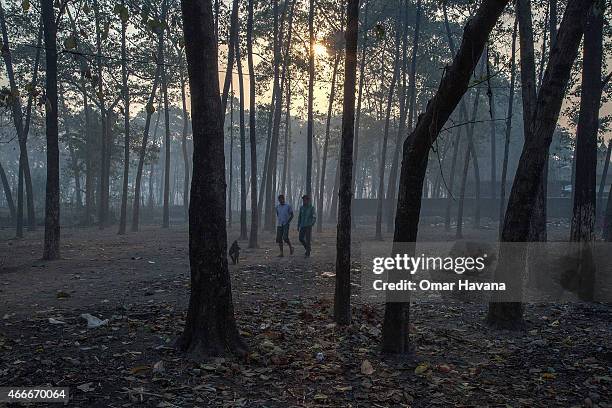 Two Bhutanese refugees walk early in the morning in the middle of the forests surrounding the Beldangi 2 refugee camp on March 13, 2015 in Beldangi,...