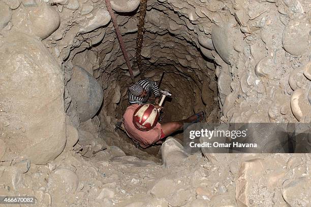 Two refugees dig a water well built by refugee Kumar Gurung to honor the memory of his grandmother, who passed away recently, inside a Kirati temple...