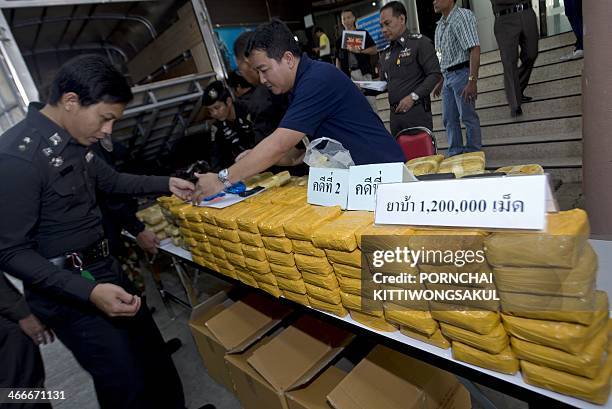 Thai policemen arrange confiscated packages of amphetamine pills during a press conference at the Narcotics Suppression Bureau in Bangkok on February...