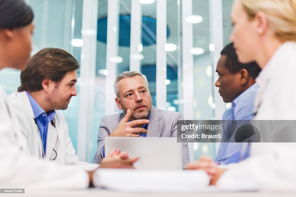 Mature businessman talking on a meeting with doctors.