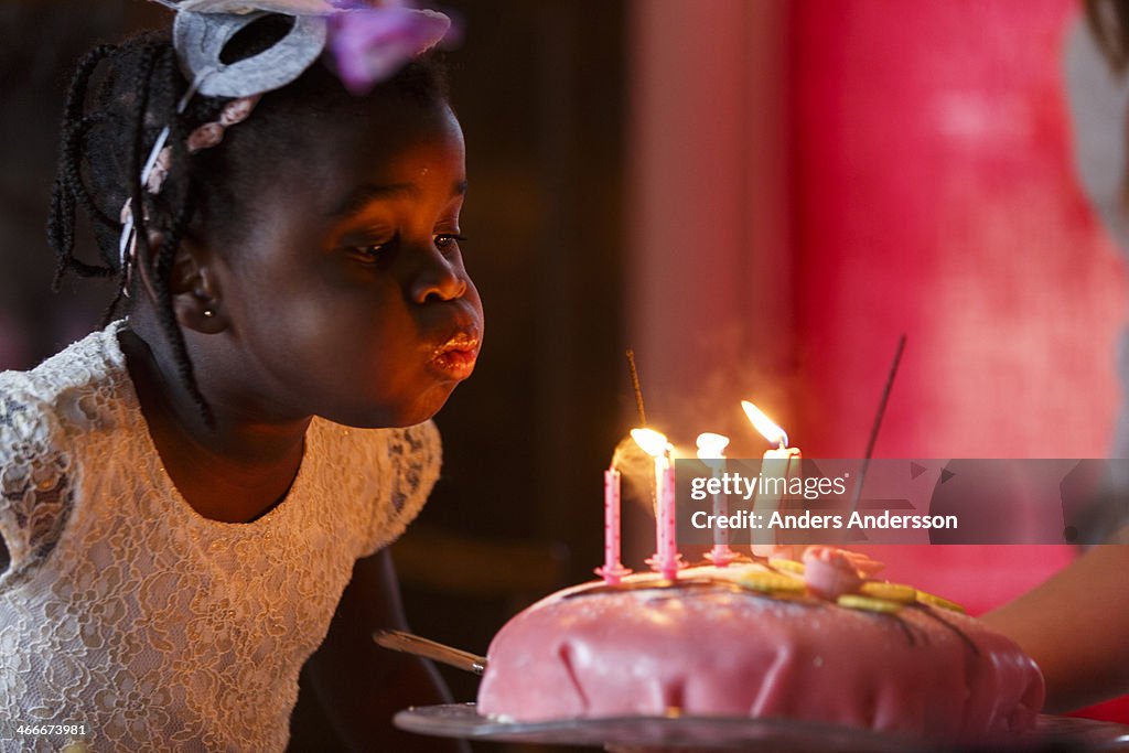 Girl blowing out candles on cake