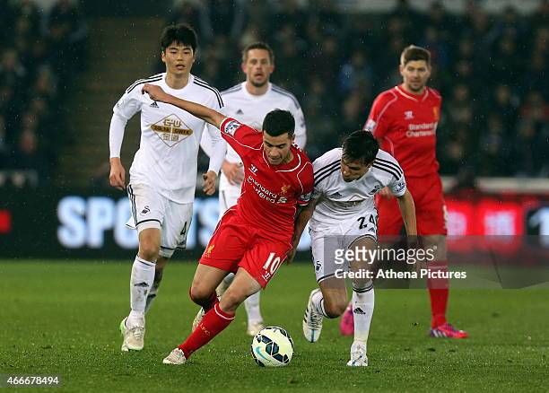 Jack Cork of Swansea is challenged by Philippe Coutinho of Liverpool during the Premier League match between Swansea City and Liverpool at the...