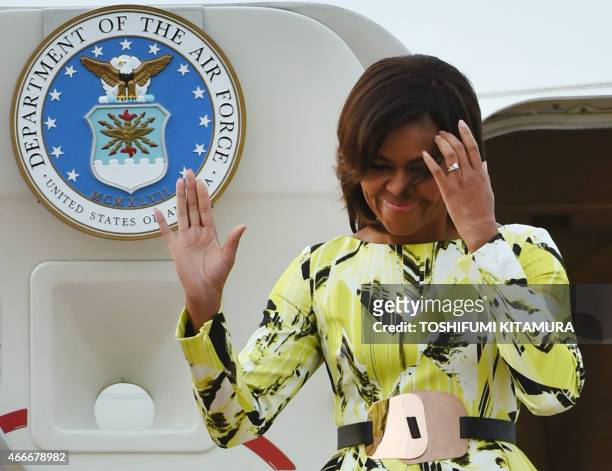 First Lady Michelle Obama waves upon her arrival at Haneda International Airport in Tokyo on March 18, 2015. Michelle Obama arrived in Japan for a...