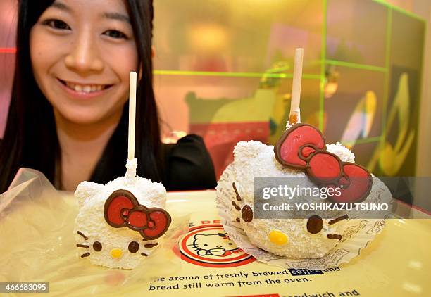 An employee of Japanese character goods maker Sanrio displays Hello Kitty shaped sweets, marshmallow and caramel apple , produced by US based...