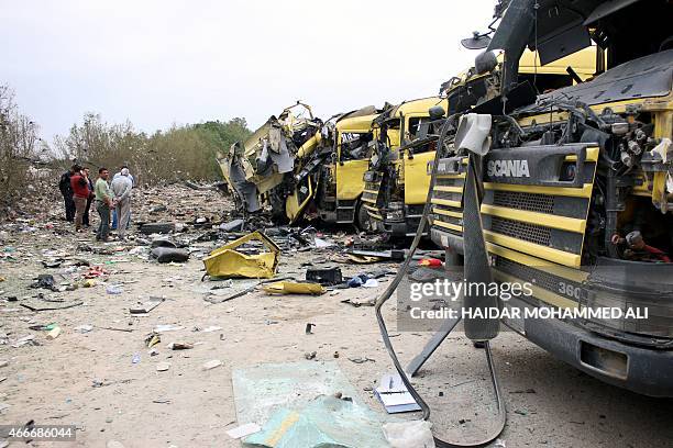 Iraqi men stand at the site of a bomb explosion in Umm Qasr port near the mainly Shiite southern city of Basra on March 18, 2015. The bomb exploded...