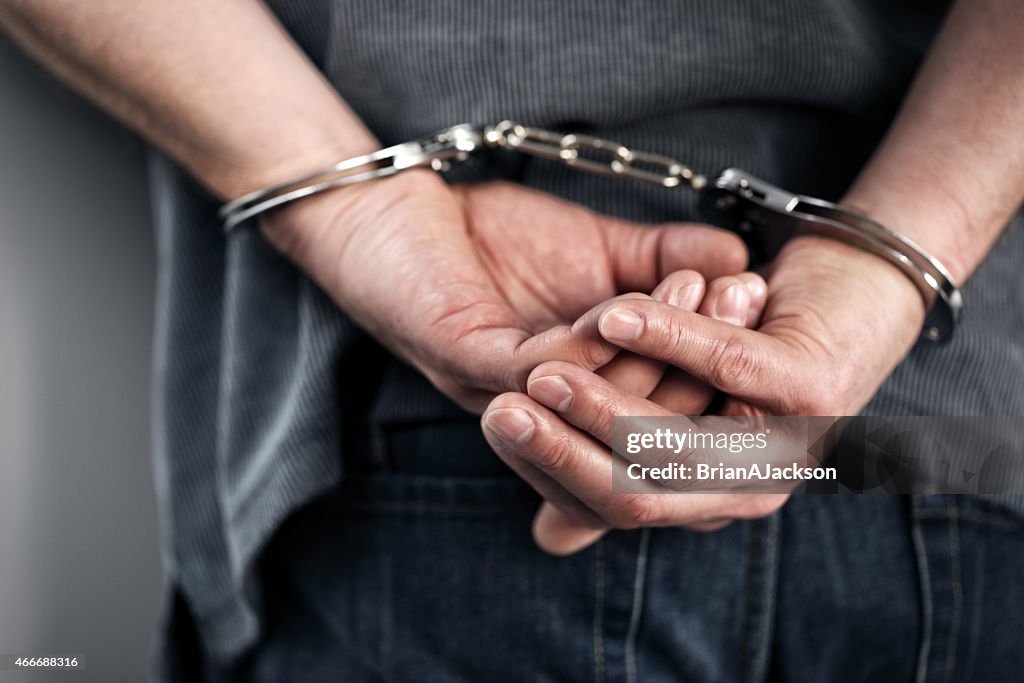 Close-up of cuffed criminal hands