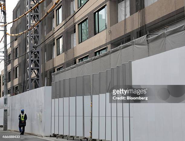 Worker walks in front of the Parkhouse Grand Minamiaoyama Takagicho residential building, developed by Mitsubishi Jisho Residence Co., a unit of...