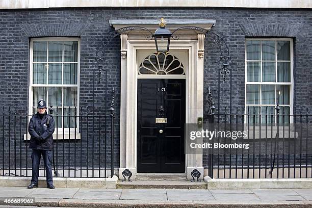 Police officer stands on duty outside the entrance to 10 Downing Street, the official residence of David Cameron, U.K. Prime minister, during a...