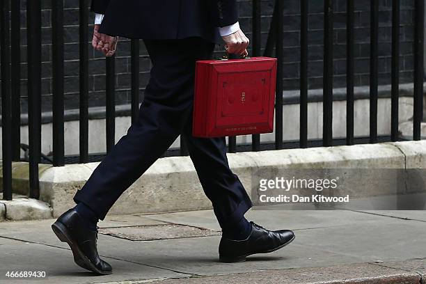 The Chancellor of the Exchequer George Osborne holds his ministerial red box as he leaves 11 Downing Street on March 18, 2015 in London, England. The...
