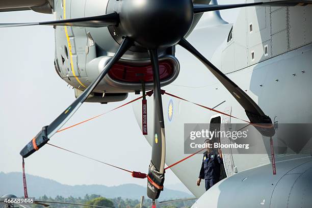 An attendee looks out of an Airbus 400M Atlas turboprop military transport aircraft, produced by Airbus Group NV, sitting on the tarmac at the...