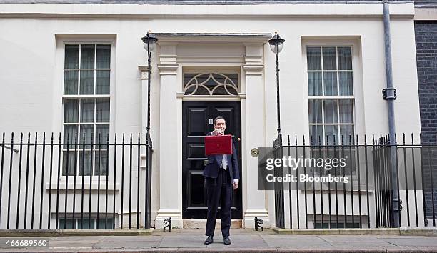 George Osborne, U.K. Chancellor of the exchequer, holds the dispatch box containing the 2015 budget as he stands outside 11 Downing Street in London,...