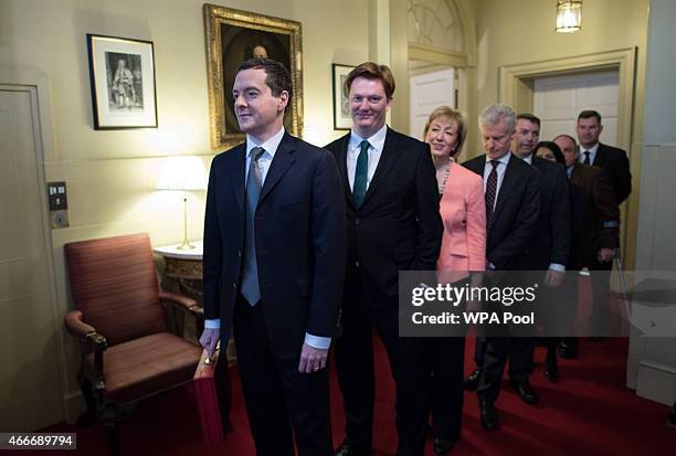 Chancellor of the Exchequer George Osborne stands with Chief Secretary to the Treasury Danny Alexander and the rest of his treasury team inside...