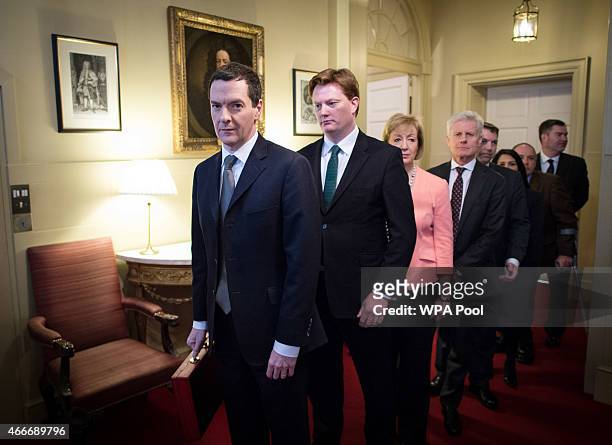 Chancellor of the Exchequer George Osborne stands with Chief Secretary to the Treasury Danny Alexander and the rest of his treasury team inside...