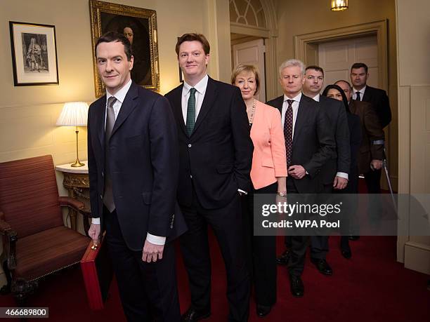 Chancellor of the Exchequer George Osborne stands with Chief Secretary to the Treasury Danny Alexander and the rest of his treasury team inside...