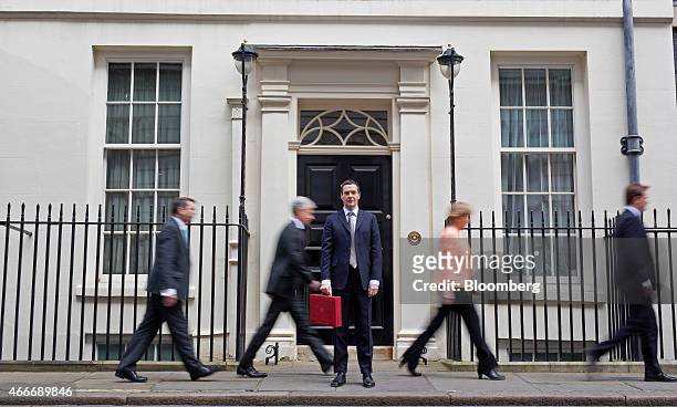 George Osborne, U.K. Chancellor of the exchequer, holds the dispatch box containing the 2015 budget, as members of the H.M. Treasury team pass behind...