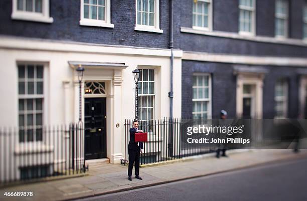 Chancellor of the Exchequer George Osborne holds his ministerial red box up to the media as he leaves number 11 Downing Street for Parliament on...