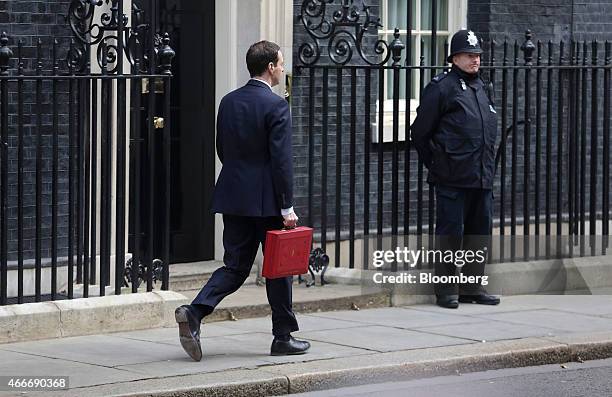 George Osborne, U.K. Chancellor of the exchequer, holds the dispatch box containing the 2015 budget as he walks past 10 Downing Street in London,...