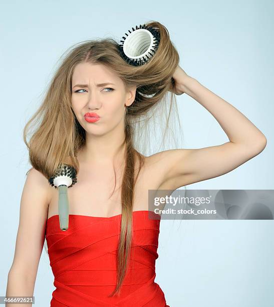 trying to brush her hair - frizzy hair stockfoto's en -beelden