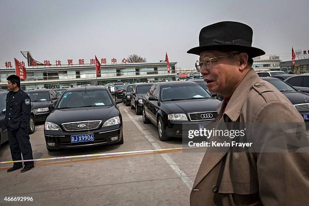 Buyer walks past cars at an auction of government vehicles on March 18, 2015 in Beijing, China. The auction was held to sell-off more than 100...