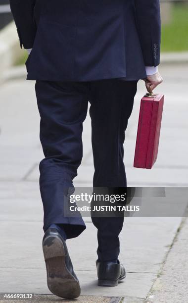 British Finance Minister George Osborne holds the Budget Box as he leaves 11 Downing Street in London, on March 18 to present the governments annual...