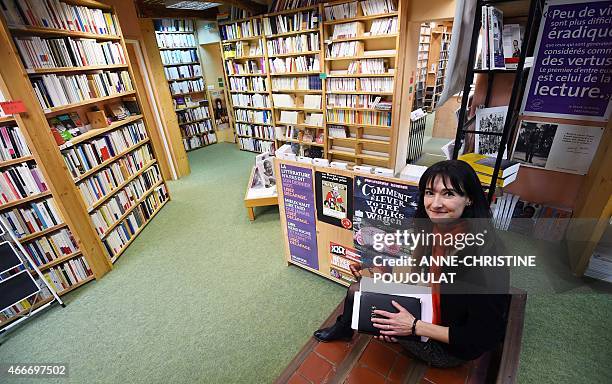 Christine Rey, new owner of the bookstore "Le Bleuet" poses on February 17, 2015 in her bookstore in Banon. AFP PHOTO / ANNE-CHRISTINE POUJOULAT