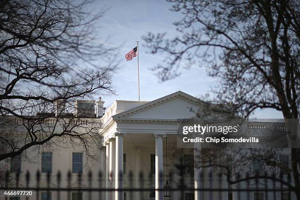 Morning sunlight strikes the flag flying above the White House March 18, 2015 in Washington, DC. The U.S. Secret Service said a letter sent to the...